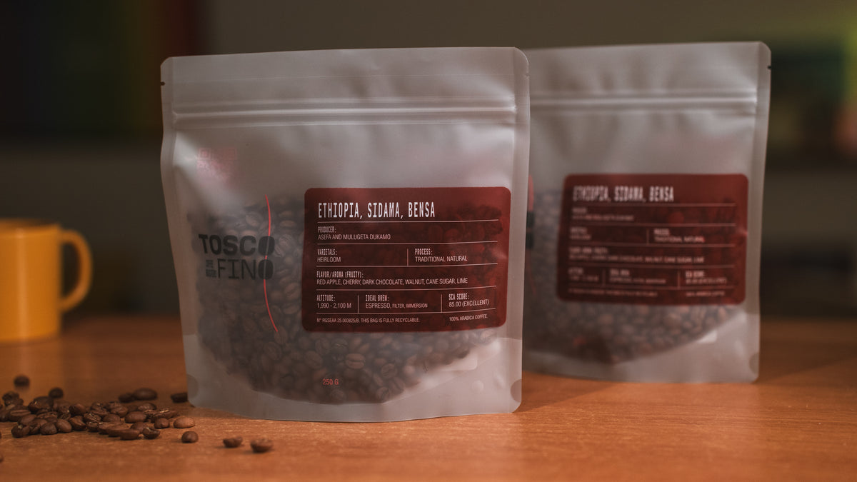 Two bags of Tosco Fino Ethiopia Sidama Bensa specialty coffee on a wooden café table