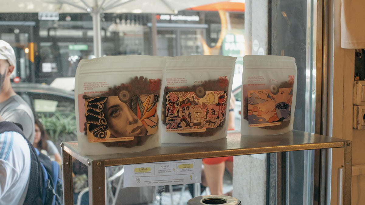 Tosco Fino coffee bags with artist artwork in the Barcelona café window — Filter Coffee Subscription, Roaster's Choice